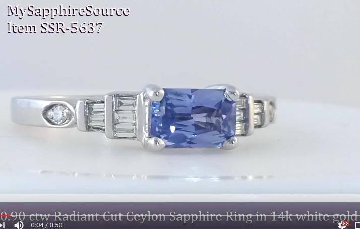 A video link featuring a radiant-cut blue sapphire center stone with baguette and round side stones, shown on a plain light background. Text overlays identify the item as a Ceylon Sapphire ring in 14k white gold.