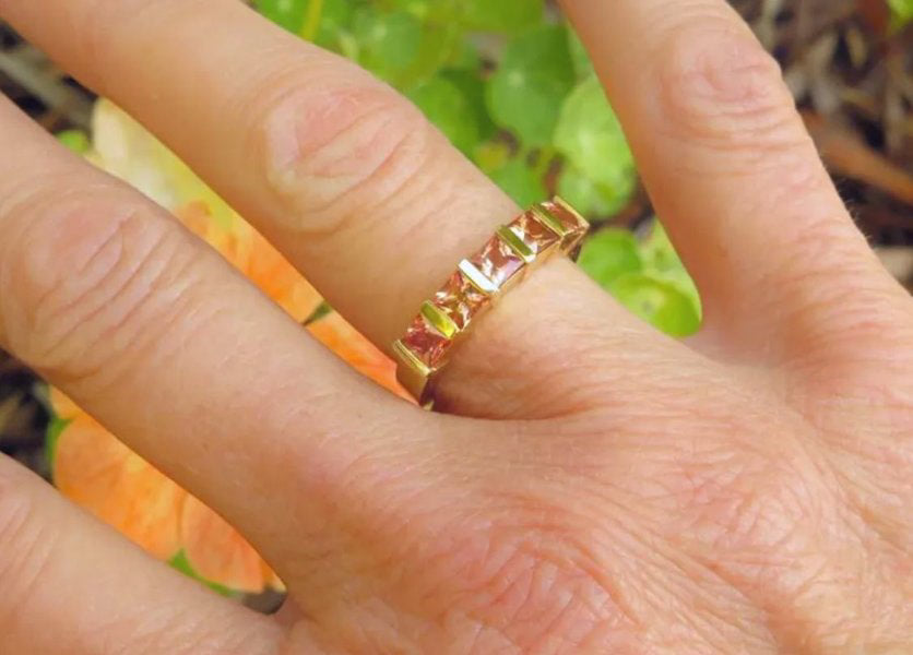 natural sapphire bar-set ring featuring peach orange and pink princess cuts