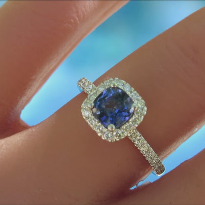 diamond halo ring with cushion cut blue sapphire in white gold on the finger