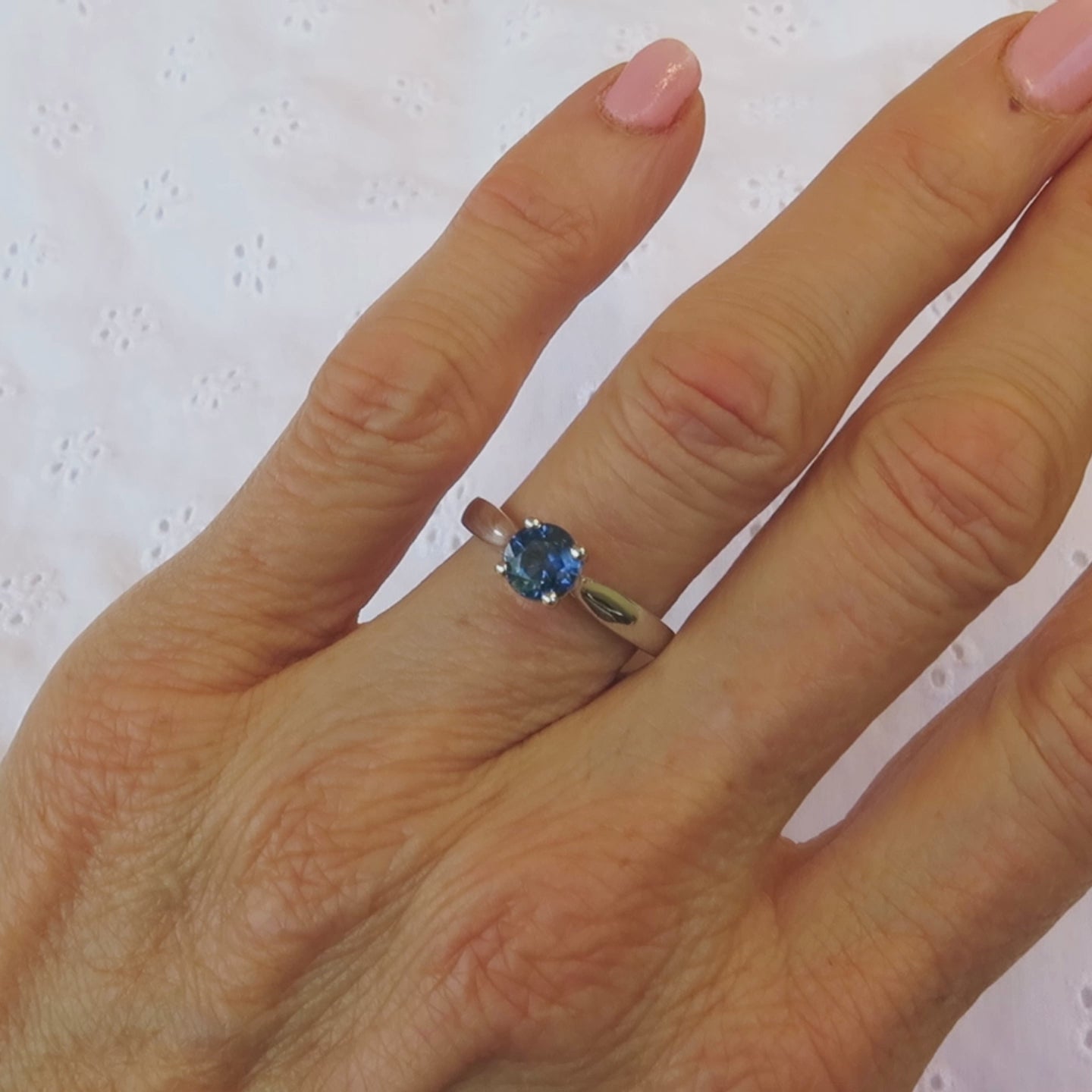 solitaire round blue sapphire ring with plain band on the hand