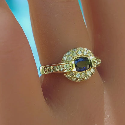 pave diamond pillow style ring with east west set oval blue sapphire in 14k yellow gold on the finger