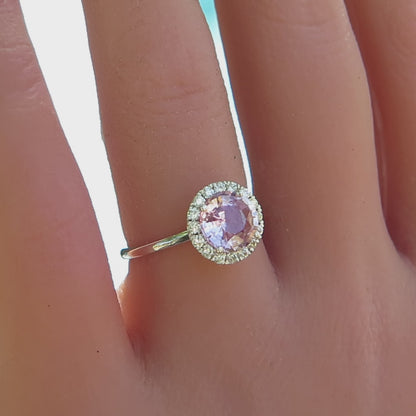 simple diamond halo ring with round light pink sapphire shown on the finger