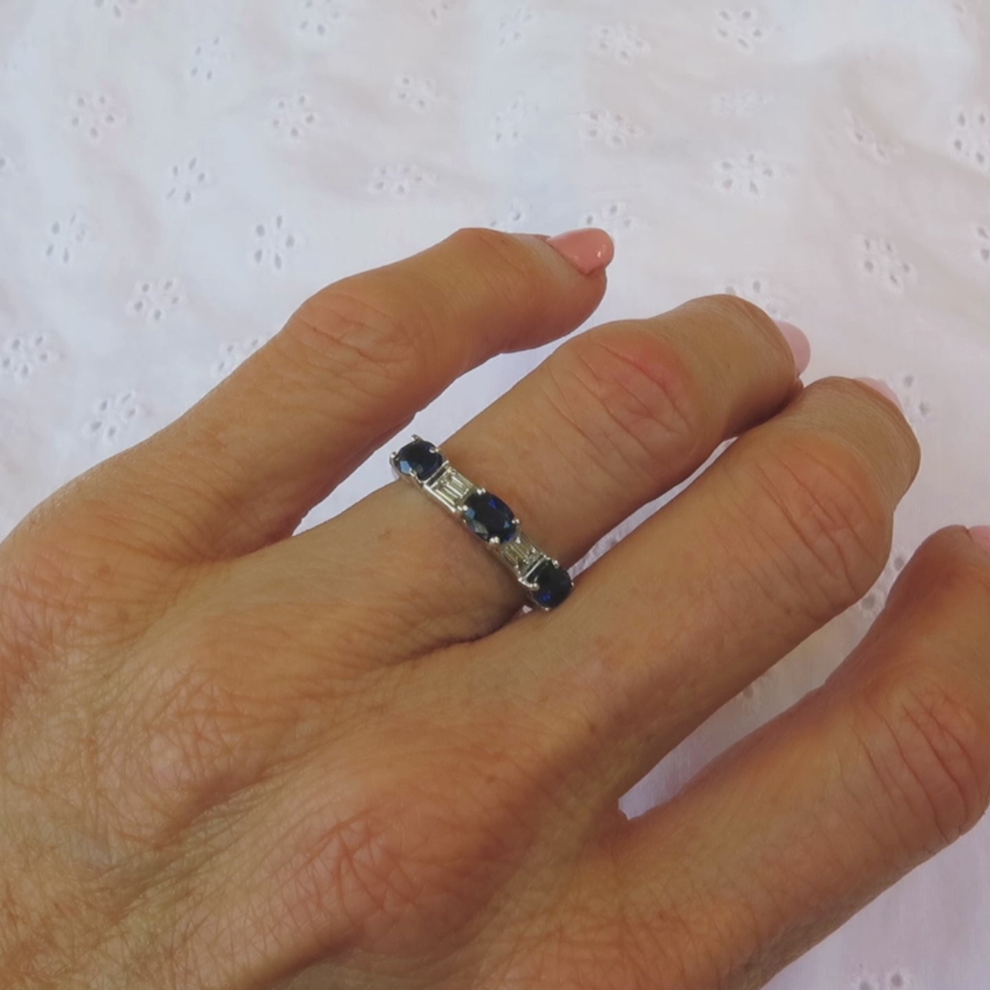 blue sapphire oval and baguette diamond ring in 18k white gold metal on a ladies' hand