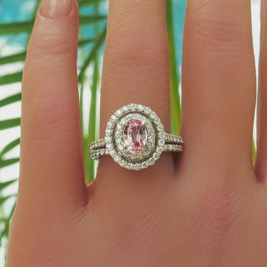 Double diamond halo ring with oval light peach sapphire in the center on the hand