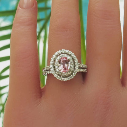 Double diamond halo ring with oval light peach sapphire in the center on the hand