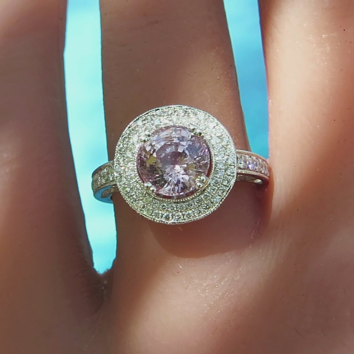 cocktail style natural round light pink sapphire with double diamond halo on the finger