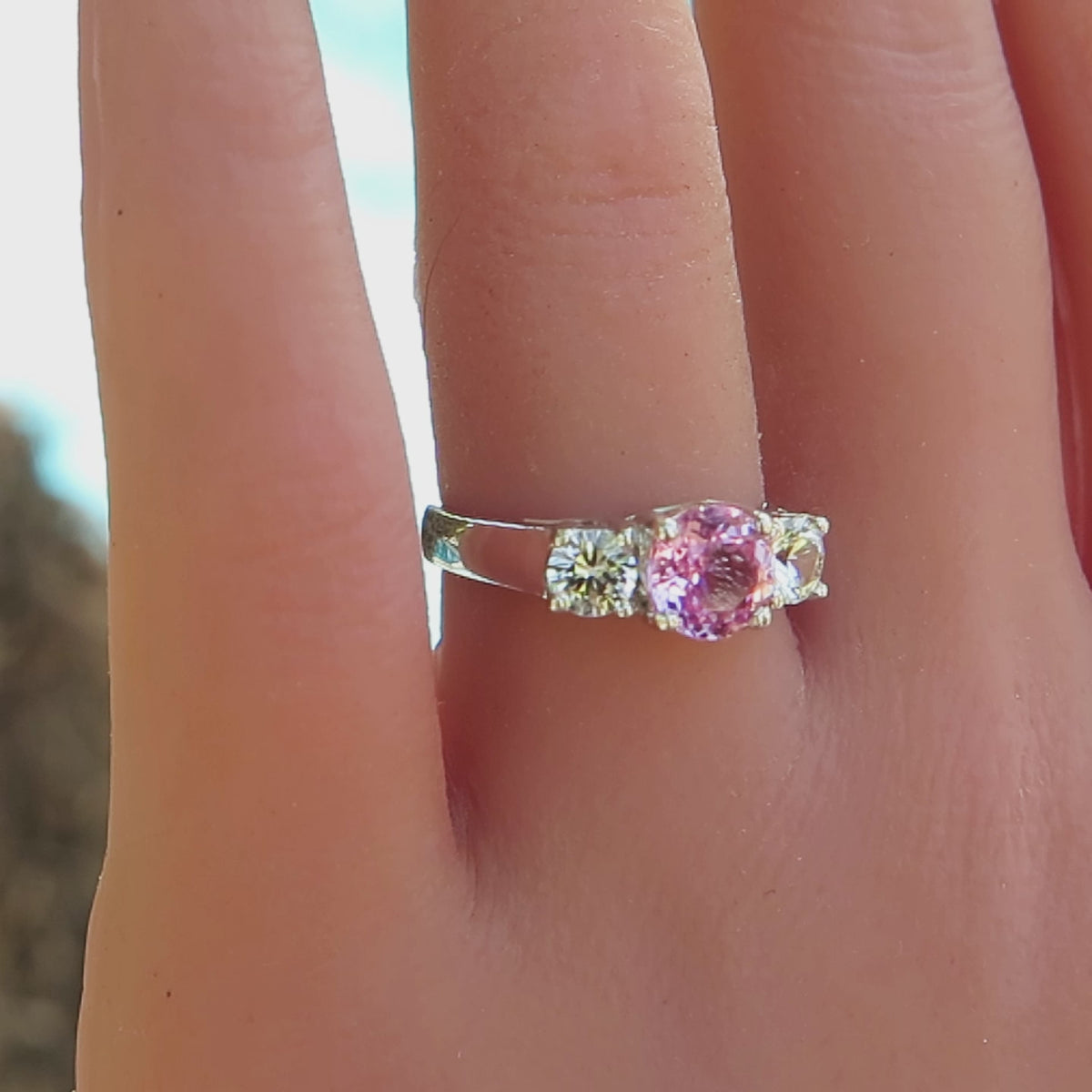 three stone pastel ink sapphire and white sapphire ring in white gold on the finger