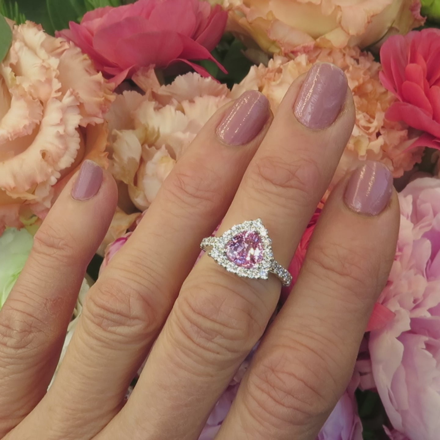 trillion cut light pink sapphire engagement ring with diamond halo setting in white metal