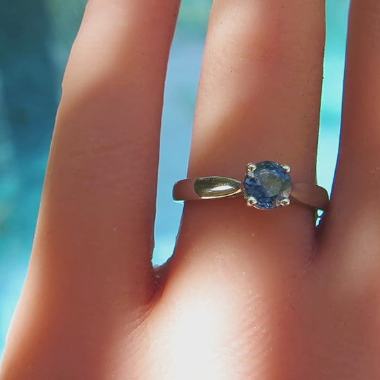 Round blue sapphire solitaire ring in white gold on the finger