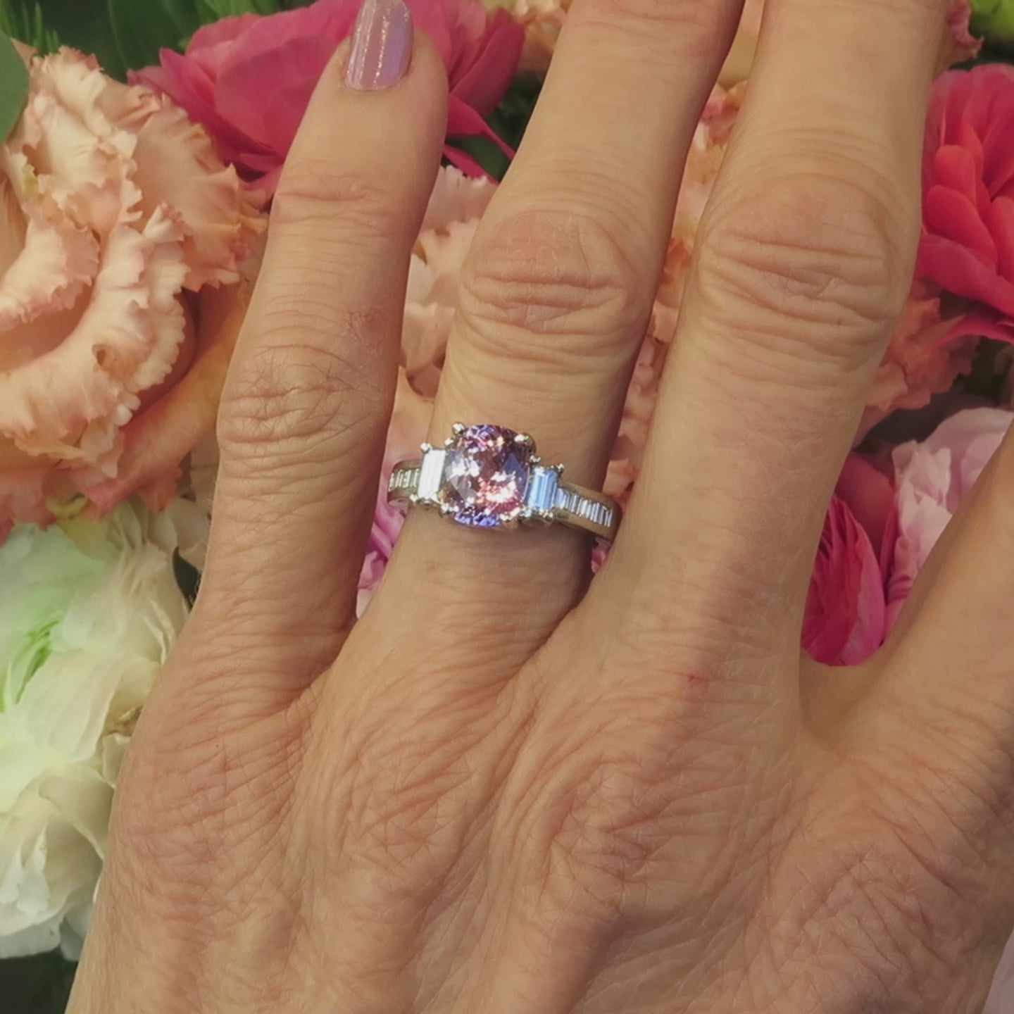 platinum engagement ring with natural cushion cut pink sapphire with two sizes of baguette diamonds on the hand