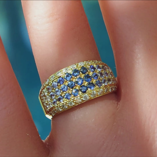 shades of blue sapphire pave ring with diamonds in 18k yellow gold on the finger