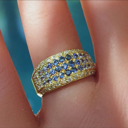 shades of blue sapphire pave ring with diamonds in 18k yellow gold on the finger
