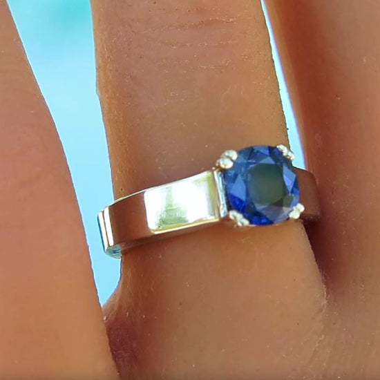 cushion cut ceylon blue sapphire in wider white gold band on a ladies' finger