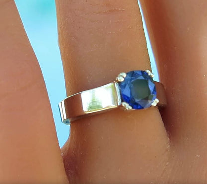 cushion cut ceylon blue sapphire in wider white gold band on a ladies' finger
