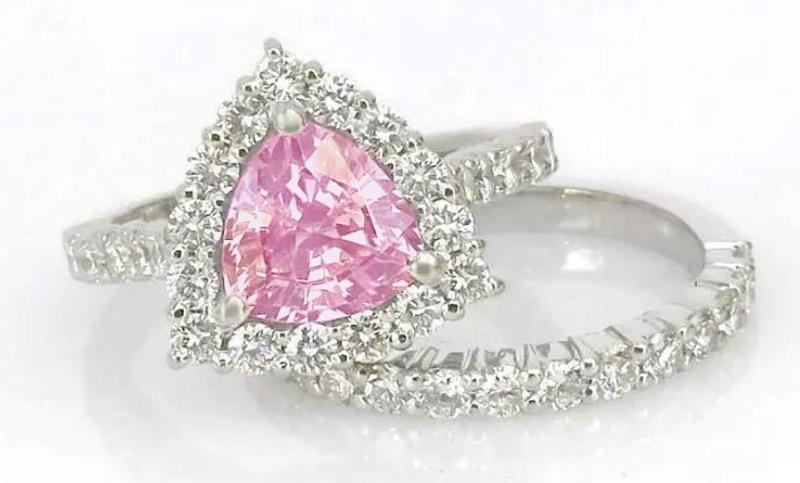 Natural trillion cut pink sapphire ring with a diamond halo in 14k white gold shown with it's matching diamond band