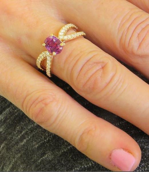 Oval cut natural purple sapphire ring in 14k rose gold shown on the hand