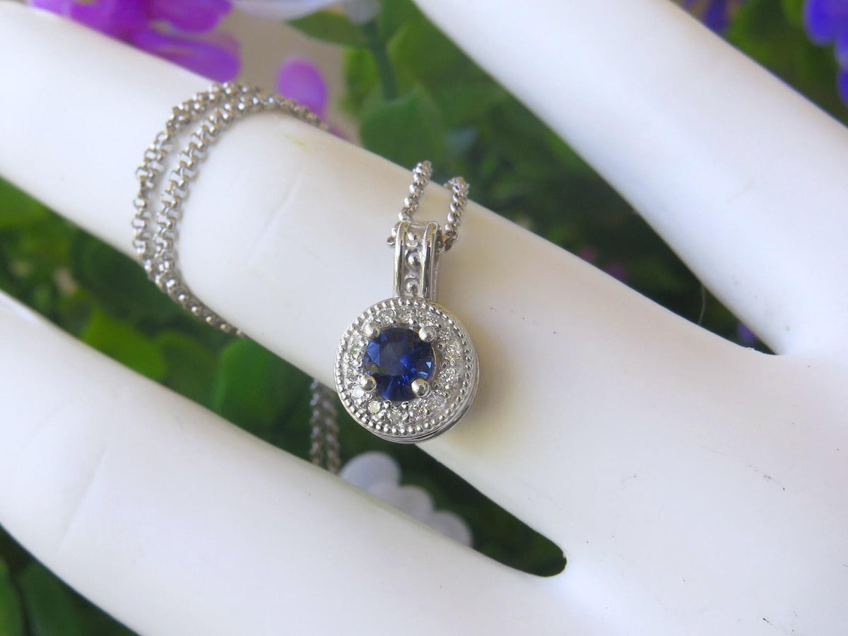 Round natural blue sapphire and diamond halo pendant in 14k white gold