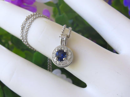 Round natural blue sapphire and diamond halo pendant in 14k white gold