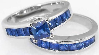 Two silver rings with blue gemstones, one featuring a square-cut center stone and the other a channel-set row of blue stones, shown on a white background.