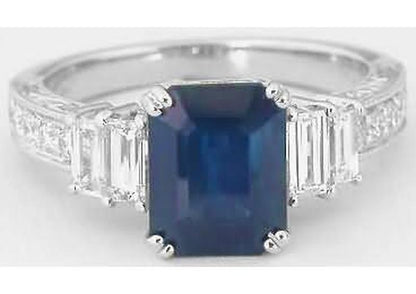 Natural Rich Blue Sapphire in an Emerald Cut Flanked by Pairs of Fine Baguette Diamonds in Vintage Inspired Setting
